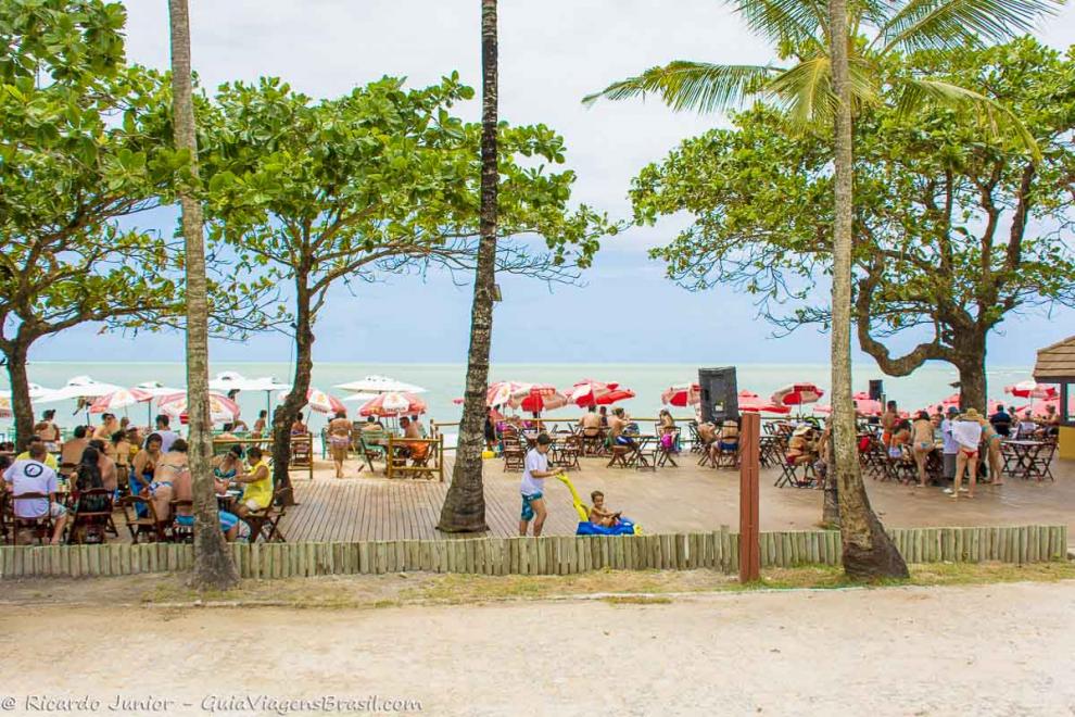 Imagem de turistas  no deck de um quiosque na Praia de Itacimirim.